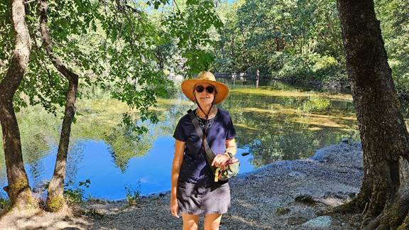 A person standing in front of a pond

Description automatically generated