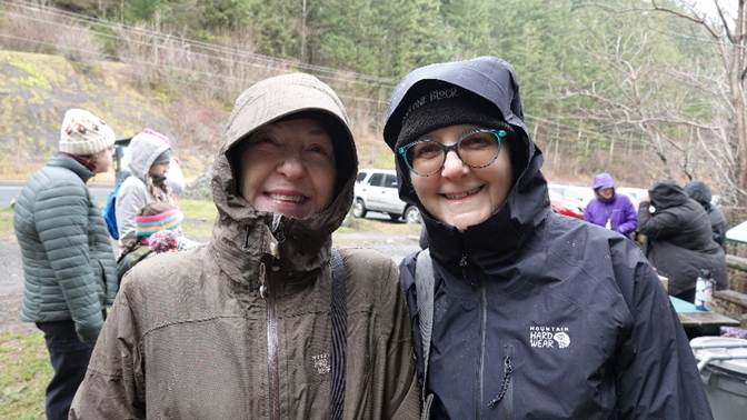 A couple of women wearing raincoats